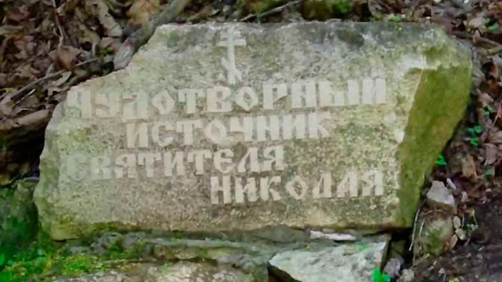 Показан памятный знак возле родника в урочище «Каменная Чаша».